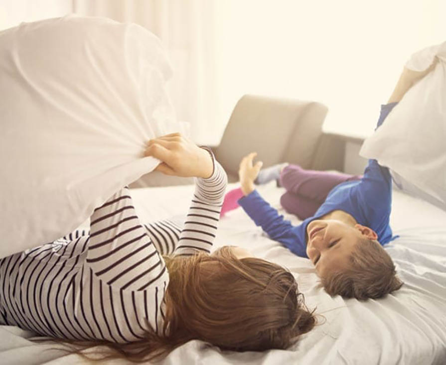 mom and son playing in bed